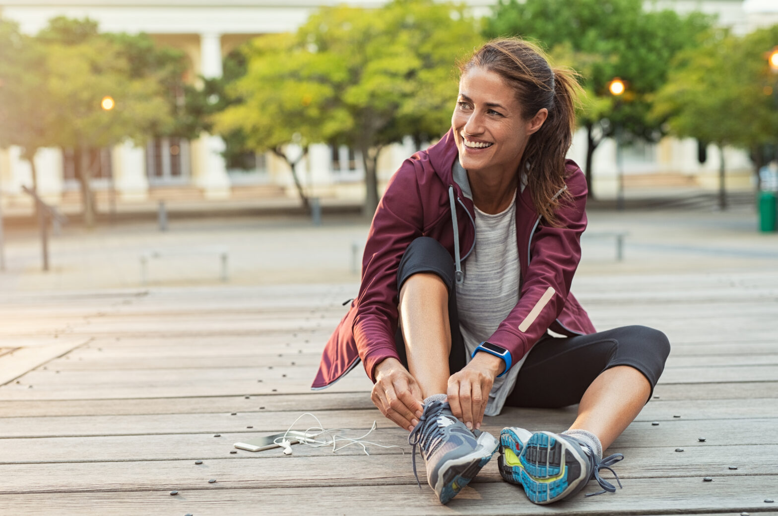 Mature,Fitness,Woman,Tie,Shoelaces,On,Road.,Cheerful,Runner,Sitting